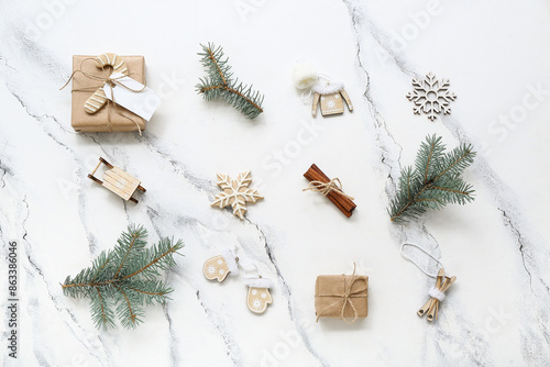 Christmas tree branches with decorations and gift boxes on white background