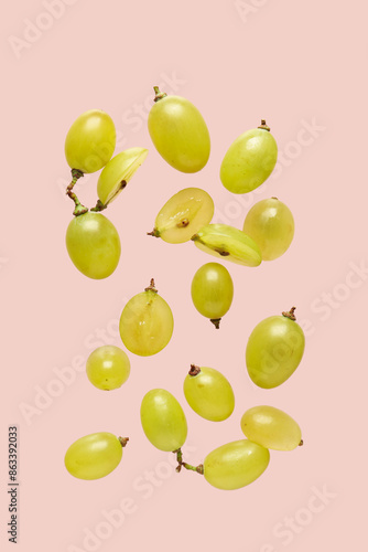 Fresh green grapes on pink background