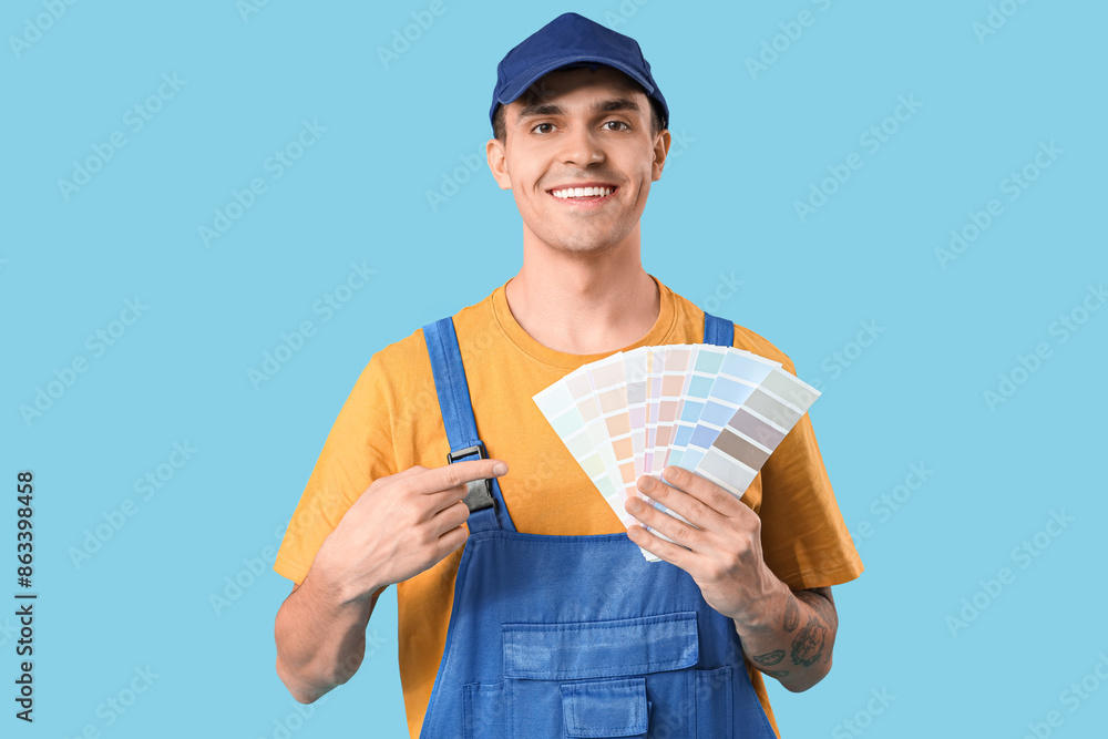 Young painter with color palettes on blue background Young painter with color palettes on blue background