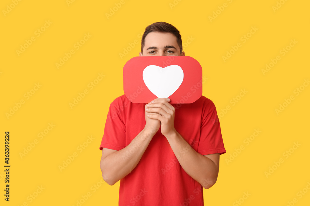 Handsome young man with heart like icon on yellow background Handsome young man with heart like icon on yellow background