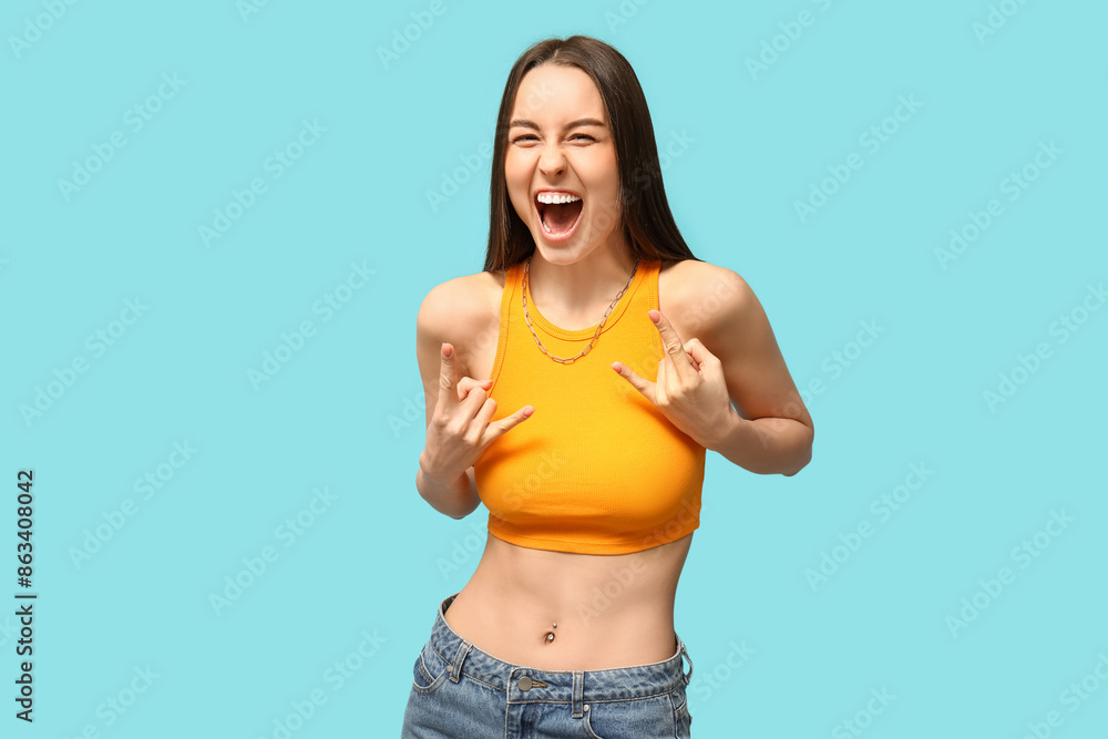 Beautiful young happy woman with piercing navel on blue background Beautiful young happy woman with piercing navel on blue background