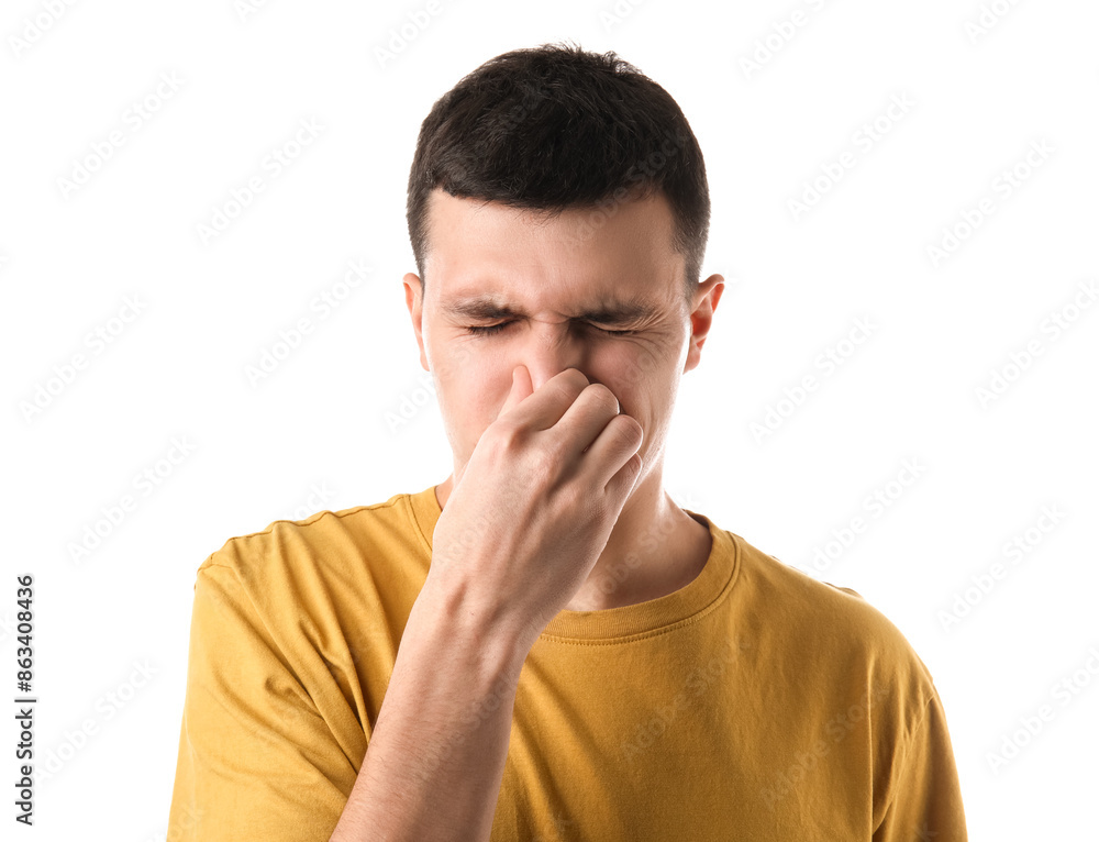 Handsome young man pinching nose because of bad smell on white background Handsome young man pinching nose because of bad smell on white background