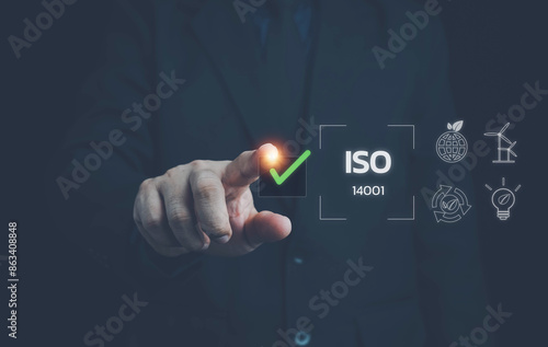 ISO 14001 concept. Businessman touching virtual screen of ISO 14001 certified for environmental management systems (EMS). Identify, control and reduce the environmental impact of activities.