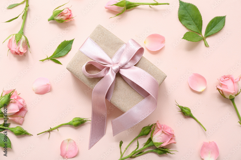 Beautiful wrapped gift box decorated with rose flowers on beige background Beautiful wrapped gift box decorated with rose flowers on beige background