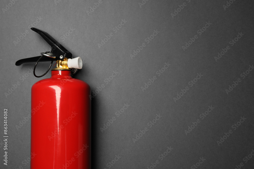One red fire extinguisher on gray background, top view. Space for text One red fire extinguisher on gray background, top view. Space for text