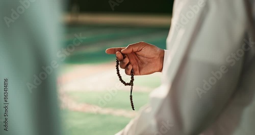 Muslim, person or hands with beads in Mosque for peace, counting or gratitude to Allah in holy temple. Tasbih, Islamic or spiritual ritual for praying to worship God on Ramadan Kareem in Saudi Arabia photo