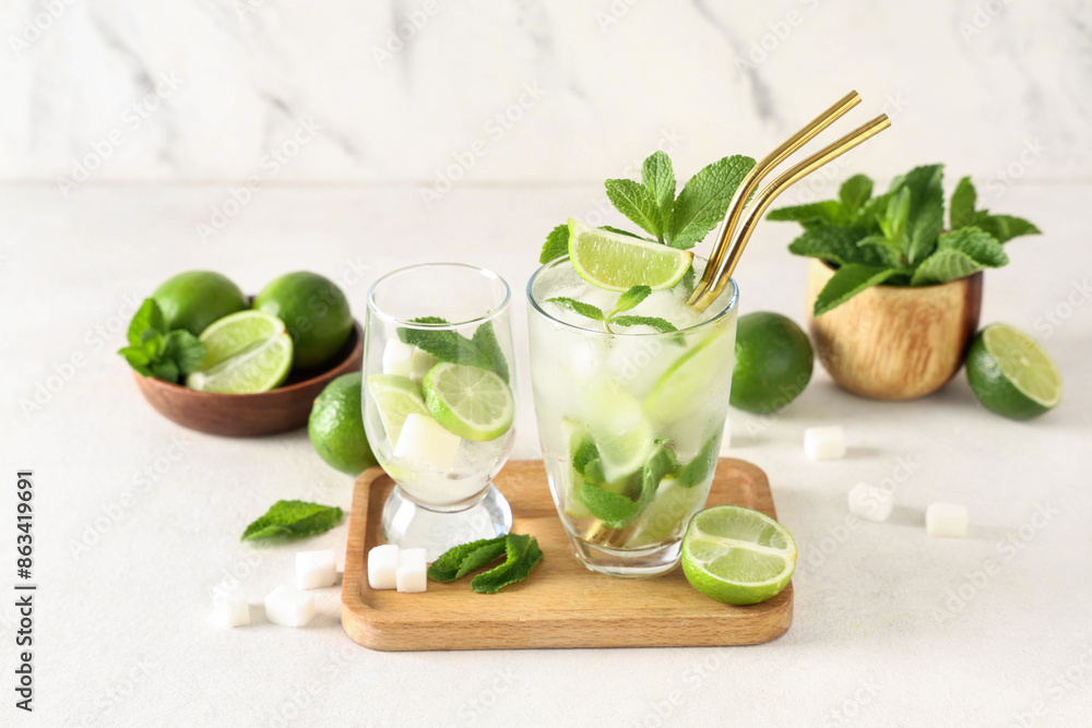 Glasses of fresh Mojito cocktail with limes and mint on white background Glasses of fresh Mojito cocktail with limes and mint on white background