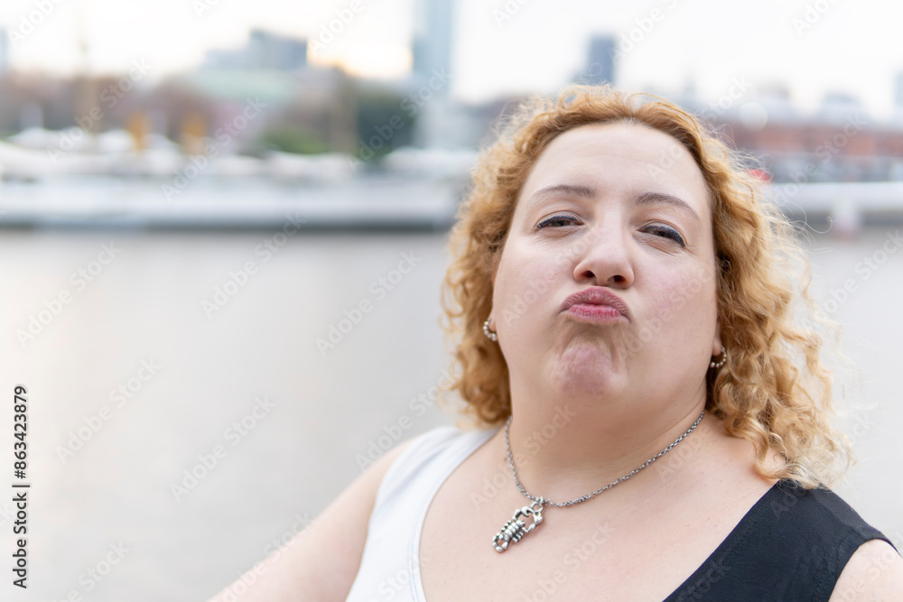Fototapeta premium Close-up portrait of plus size blonde woman blowing a kiss