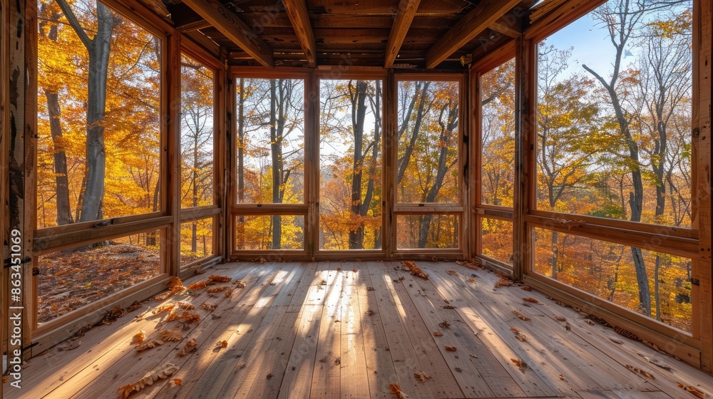 Fototapeta premium A large open room with a view of trees and leaves. The room is empty and has a lot of natural light coming in through the windows