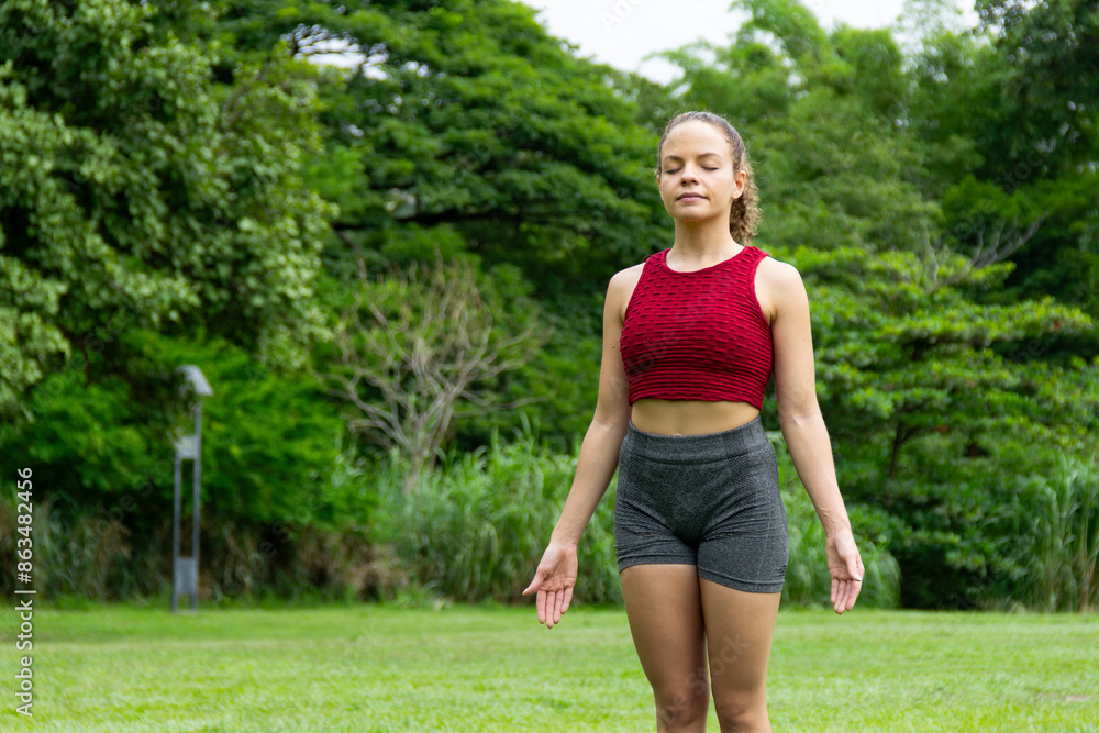 Beautiful latin hispanic woman standing in mat meditating during yoga session in the outdoors in the morning. Mental health and focused. Mountain tadasana pose Beautiful latin hispanic woman standing in mat meditating during yoga session in the outdoors in the morning. Mental health and focused. Mountain tadasana pose