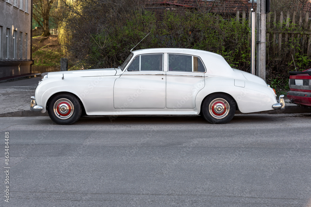 Fototapeta premium Classic White Car Parked On An Empty City Street. Retro Vehicle From The Side