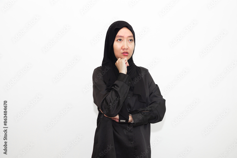 Photo of bored, annoyed hijab-wearing woman wearing chin. wearing a shirt looks empty space with isolated white color background Photo of bored, annoyed hijab-wearing woman wearing chin. wearing a shirt looks empty space with isolated white color background