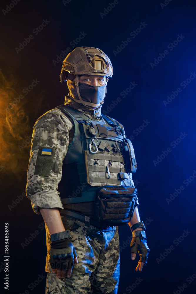Fototapeta premium Portrait of a Tactical Soldier in Combat Gear against an Intense Orange and Blue Background