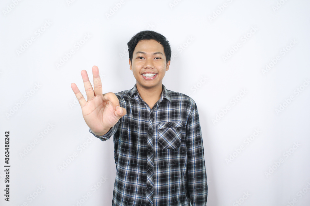 smiling asian man in casual plaid shirt showing okay gesture isolated on white smiling asian man in casual plaid shirt showing okay gesture isolated on white