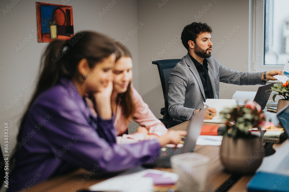 A multicultural team of young entrepreneurs analyzes statistics and works on a project during a business meeting at a startup office. A multicultural team of young entrepreneurs analyzes statistics and works on a project during a business meeting at a startup office.