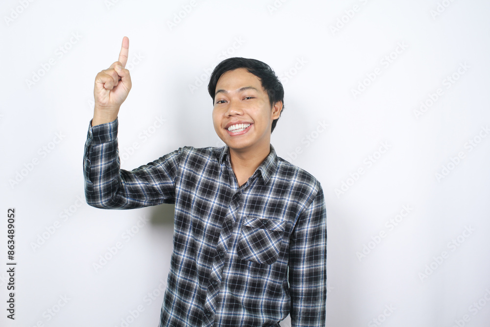young asian man smiling with pointing hands to above isolated young asian man smiling with pointing hands to above isolated