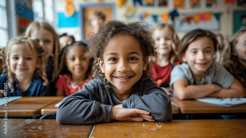 happy diverse children in an elementary school classroom sitting at desks smiling and learning together
