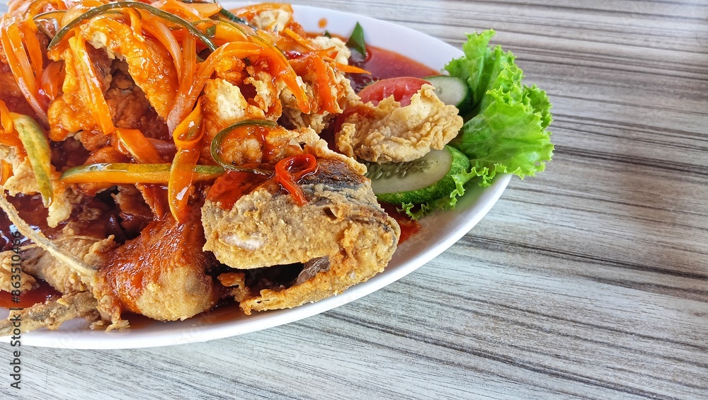 a portion of gurame asam manis is an Indonesian dish made from dry fried gourami fish and given sweet and sour seasoning. a portion of gurame asam manis is an Indonesian dish made from dry fried gourami fish and given sweet and sour seasoning.