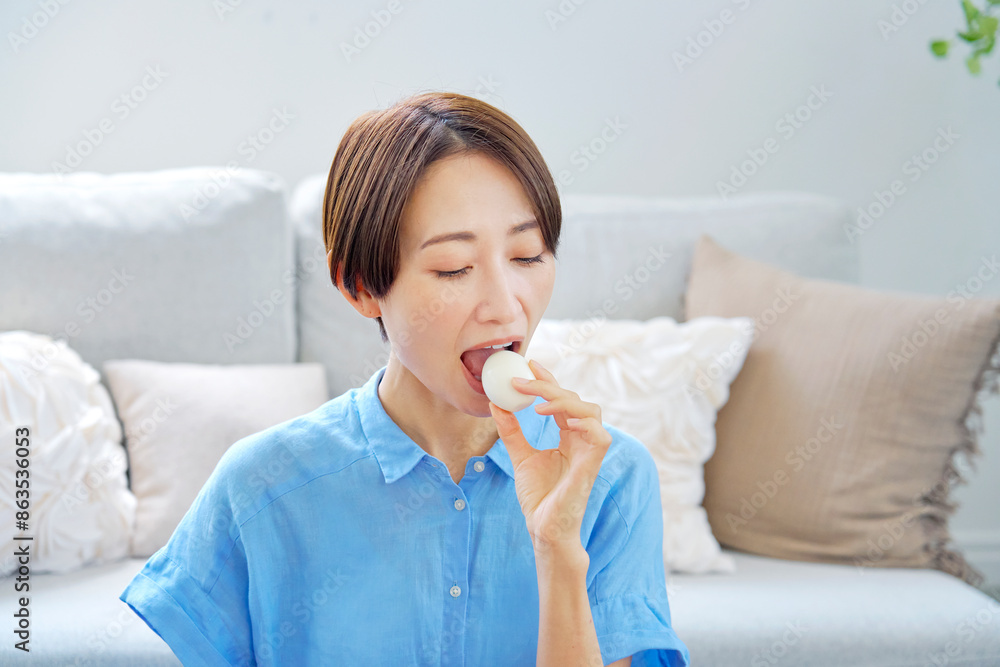自宅でゆで卵を食べる女性 自宅でゆで卵を食べる女性