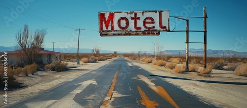 A Rusted Motel Sign Overlooking a Desert Highway in the Daytime