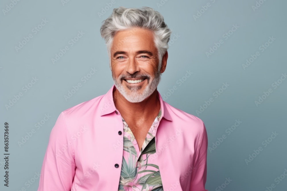 Handsome senior man with grey hair smiling at camera while standing against grey background Handsome senior man with grey hair smiling at camera while standing against grey background
