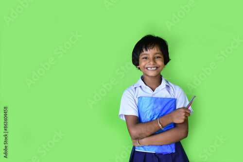 Portrait of a school girl wearing uniform holds note books in hand photo