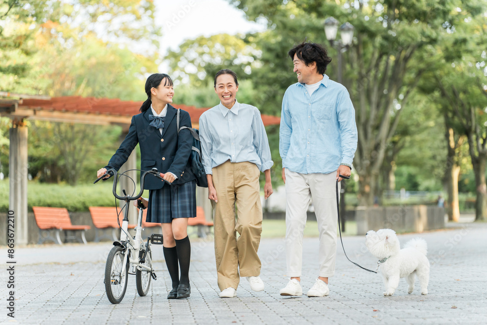 Fototapeta premium 愛犬の散歩をする中学生・高校生と両親の家族・ファミリー（犬・ペット・娘・両親・3人） 