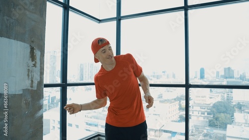 Motion shot of energetic caucasian hipster dance together near window sky scraper. Stylish energetic dancer pose while looking at camera. Outdoor sport 2024. Freestyle dancing. Endeavor. © Summit Art Creations