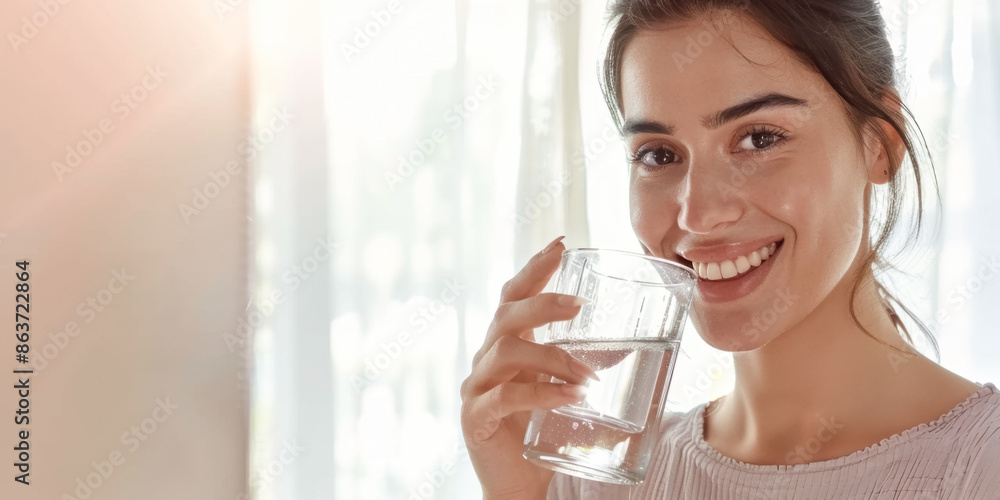 Woman smiling and holding a glass of water Woman smiling and holding a glass of water