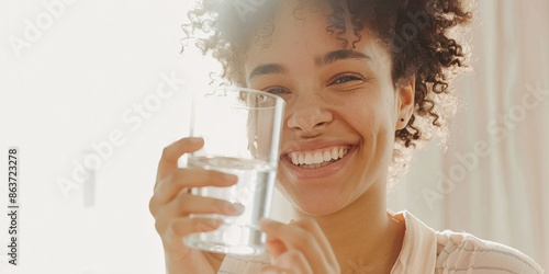 Woman smiling and holding a glass of water