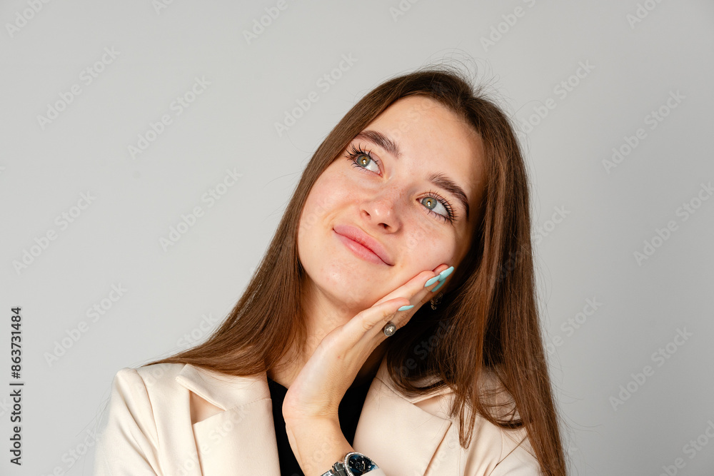 Young Woman In Black Shirt Pondering a Thought Against a Gray Backdrop Young Woman In Black Shirt Pondering a Thought Against a Gray Backdrop