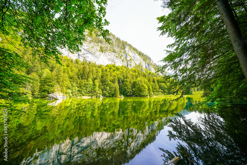 View of the Berglsteiner Lake with the surrounding green nature. Idyllic mountain lake in the Alpbachtal in Tyrol near Kufstein. Landscape in Austria.
 photo