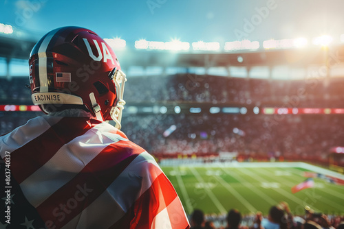 Stock photography featuring a panoramic clear image of an enthusiastic football fan with a USA flag, standing in front of a sunlit football stadium, highlighting the detailed footb photo