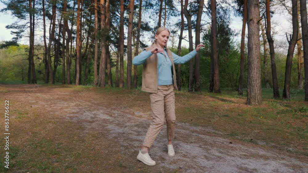 Cheerful woman rehearsing a waltz dance in a pine forest Cheerful woman rehearsing a waltz dance in a pine forest