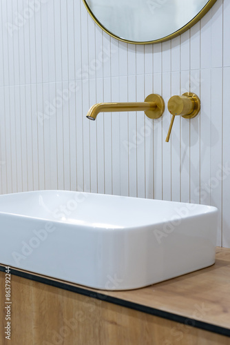 Obraz na płótnie Bronze bathroom water tap in a bathroom finished with white tiles. Minimalist bathroom finish. Photographed in natural light. w salonie