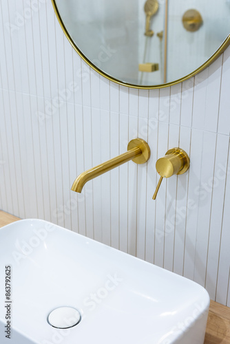 Obraz na płótnie Bronze bathroom water tap in a bathroom finished with white tiles. Minimalist bathroom finish. Photographed in natural light. w salonie