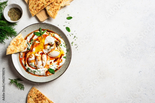 Turkish eggs Cilbir and fresh pita bread photo