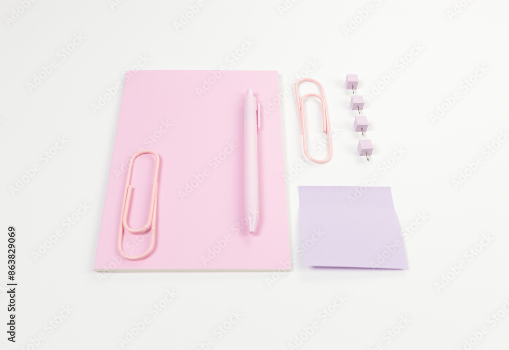 Top view of pink notebook on white background. Sticky note, paperclips, pen and pins. School, office wallpaper. Flat lay, copy space. Top view of pink notebook on white background. Sticky note, paperclips, pen and pins. School, office wallpaper. Flat lay, copy space.
