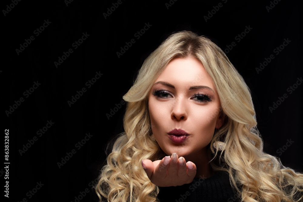 Woman blowing kiss, blonde curls, black turtleneck Woman blowing kiss, blonde curls, black turtleneck