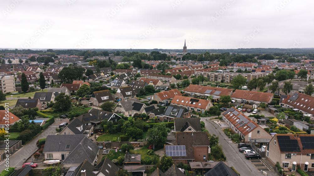 Obraz premium Aerial shot of houses with solar panels on roof in a street in a residential area neighborhood in Steenwijk, Overijssel, The Netherlands.