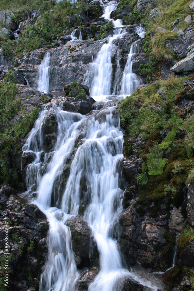 Vertical photo of the silky waterfall on the Transfagarasan mountain road in Romania Vertical photo of the silky waterfall on the Transfagarasan mountain road in Romania