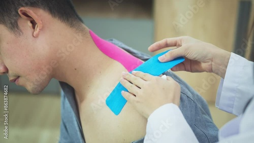 Shot in slow motion of physical therapist applying kinesiology tape on patient neck during the medical treatment in clinic photo
