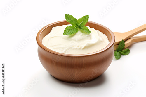 a bowl of white cream with green leaves