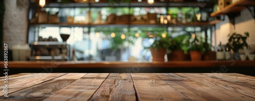 A rustic wooden table in sharp focus with a blurred coffee shop interior in the background. The scene is warm and inviting, featuring potted plants, hanging lights, and a cozy atmosphere. © Dalibor