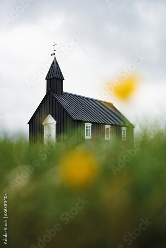 Obraz na płótnie Stunning view of the black church of Budir with defocused grass in the foreground. Búðakirkja is a small wooden church located on the south side of Snæfellsnes, Iceland. w salonie