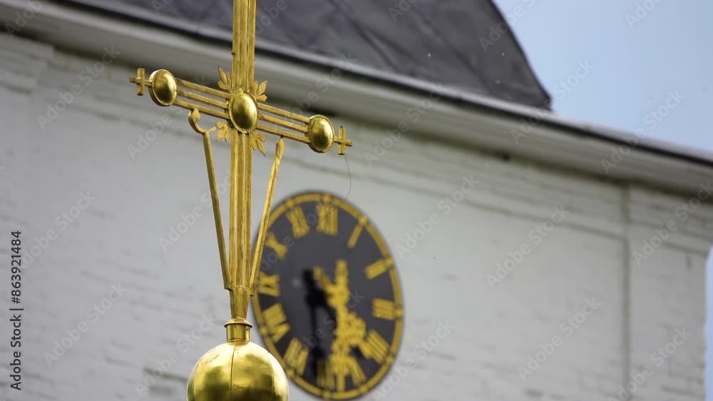 Focus transition: Big watch and cross on Cathedral of Assumption of Blessed Virgin Mary is an Orthodox church. Temple is located in ancient Russian fortress of Kremlin, Dmitrov, Moscow region, Russia. Focus transition: Big watch and cross on Cathedral of Assumption of Blessed Virgin Mary is an Orthodox church. Temple is located in ancient Russian fortress of Kremlin, Dmitrov, Moscow region, Russia.