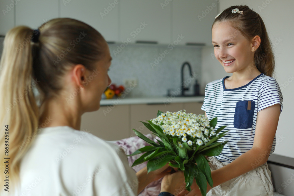 Nice little happy girl presenting bouquet to her mother in living room. Nice little happy girl presenting bouquet to her mother in living room.