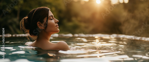 Lifestyle portrait of beautiful brunette woman relaxing in luxury hot springs pool