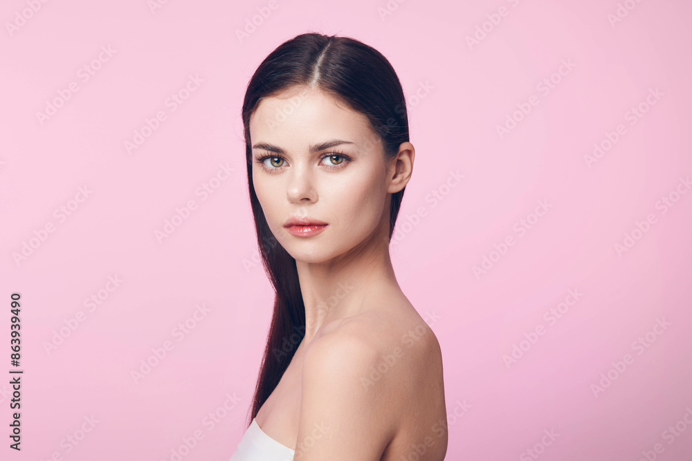 Beautiful young woman with long black hair posing against a pink background Beautiful young woman with long black hair posing against a pink background