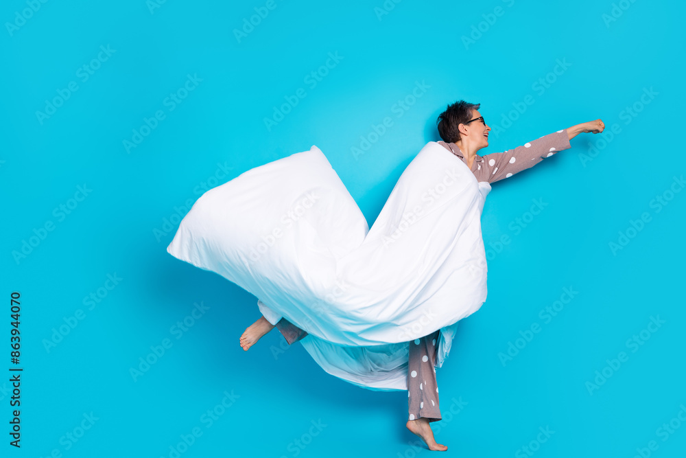 Naklejka premium Photo of crazy funny lovely senior woman wear stylish pajama fly empty space isolated on blue color background